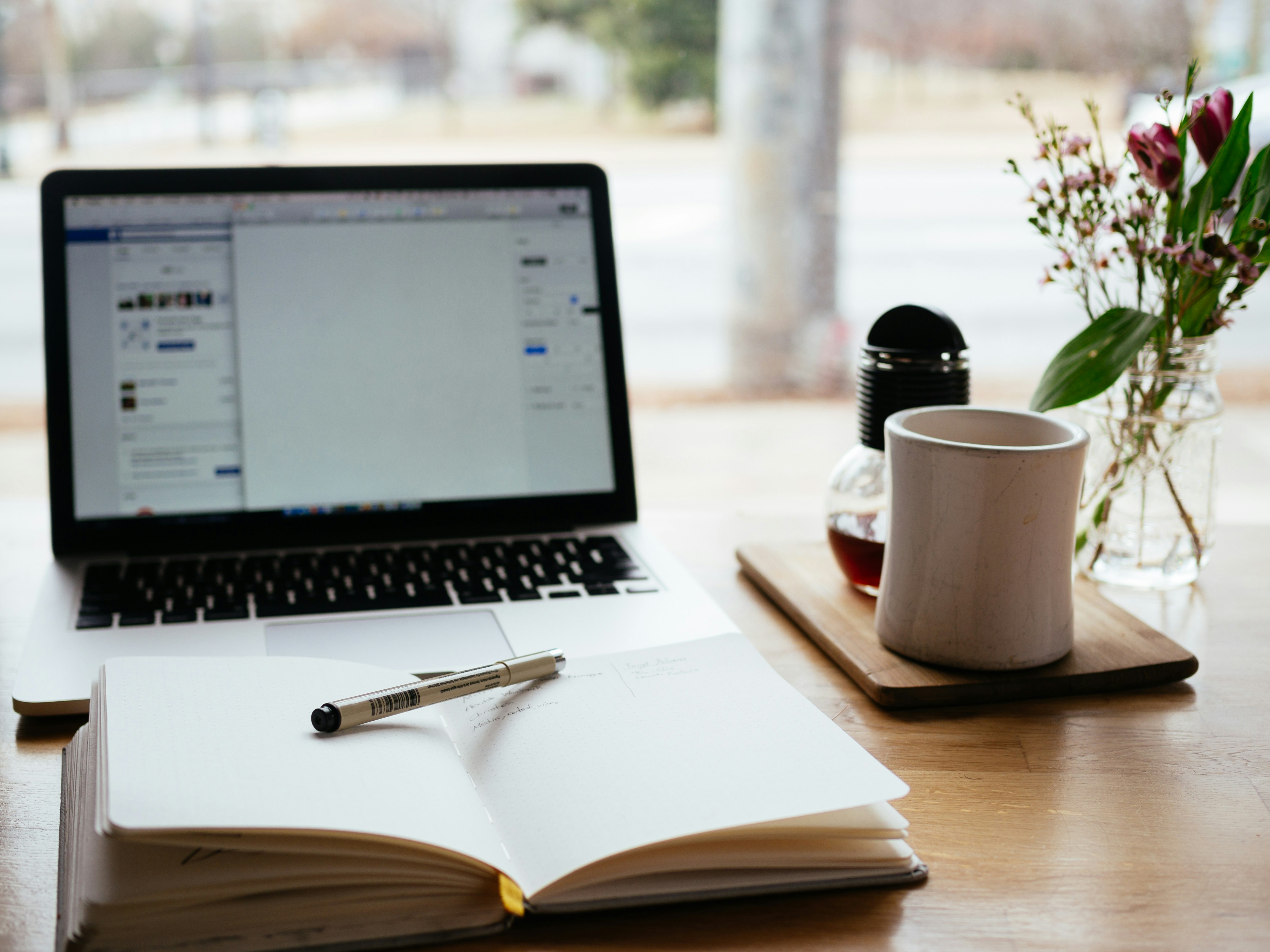 notebook and laptop on table -  How To Rephrase A Thesis Statement